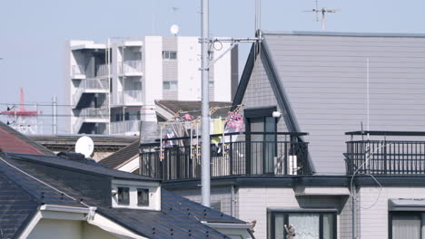 Wäsche-Auf-Kleiderbügel-An-Der-Wäscheleine,-Die-Im-Wind-Auf-Dem-Balkon-Eines-Japanischen-Hauses-In-Tokio,-Japan,-Wogt