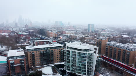 Aerial-drone-shot-of-Limehouse-London-in-snow-DLR-train