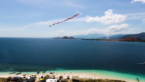 aerial-view-of-Kenawa-Island,-Sumbawa,-Indonesia,-drone-close-up-to-kite-flying-over-the-archipelago-revealing-a-stunning-wild-nature-tropical-seascape-for-holiday-destination