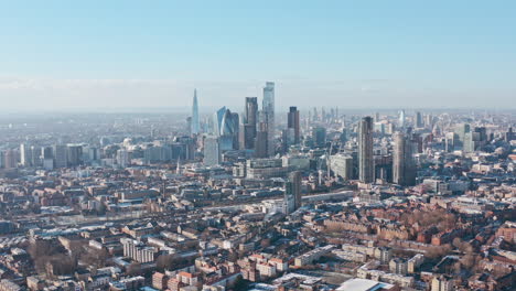Tight-cinematic-rotating-aerial-drone-shot-of-City-of-London-skyscrapers-clear-day-after-snow