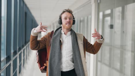 Stylish-young-man-dancing-in-headphones-in-the-hallway