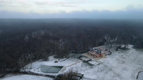 Großes-Haus-Am-Waldrand-Im-Winter-Luftaufnahmen-4k