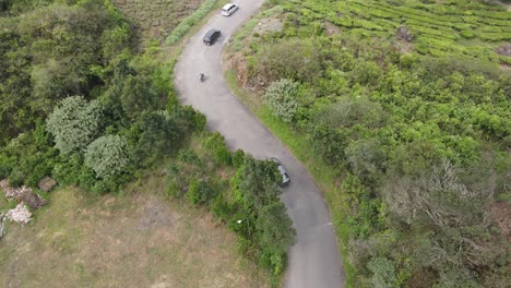 Drone-tilt-up:-aerial-view-of-highway-on-the-hill-with-passing-vehicle