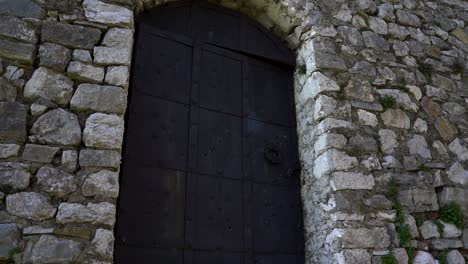 Iron-heavy-locked-door-of-stone-building-located-inside-medieval-castle