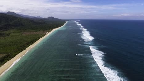 Luftaufnahme-Des-Tropischen-Sandstrandparadieses-Mit-Großen-Weißen-Schaumwellen,-Die-Auf-Die-Epische-Inselseelandschaft-Des-Barriererriffs-Krachen,-Reiseziel-West-Sumbava-Indonesien