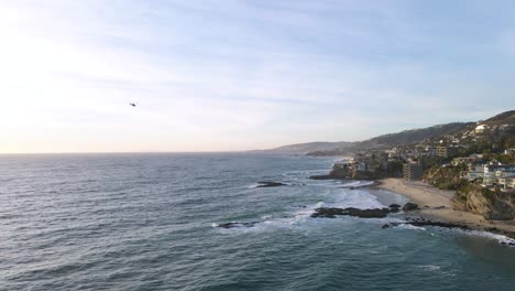 Aerial-view-of-a-helicopter-flying-on-California-coastline-above-the-ocean