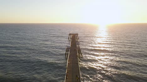 An-aerial-drone-shot-fly-over-the-San-Clemente-Pier,-California-during-sunset