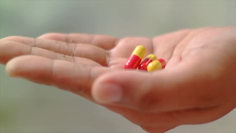 close-up-of-hand-received-some-medicine-capsules