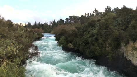Looking-upstream-against-the-current-of-Huka-Falls-near-the-town-of-Taupo-on-the-north-island-of-New-Zealand,-slow-motion