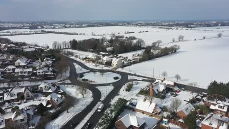 Aerial-pivot-with-parallax-effect-above-snow-covered-roundabout