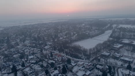 Aerial-overview-of-small-town-covered-in-snow-at-dawn