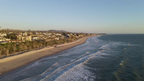 A-vast-aerial-drone-shot-of-San-Clemente-State-Beach,-showing-a-long-sandy-coastline-in-the-evening-time-with-clear-sky
