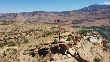 Drone-footage-of-flag-on-top-of-mountain-waving-in-the-the-wind