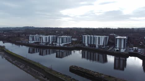 Early-morning-aerial-view-riverside-waterfront-contemporary-apartment-office-buildings-canal-regeneration-real-estate-tracking-dolly-left