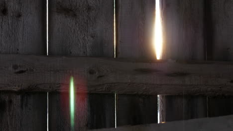 Beautiful-sun-flares-through-gaps-of-wooden-fence-or-wall
