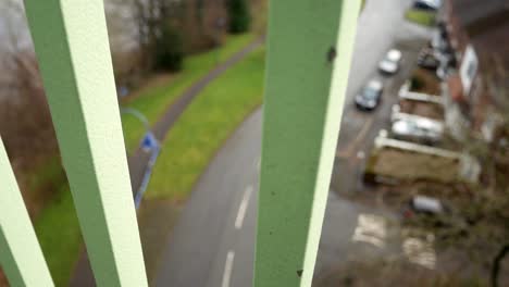 Looking-down-through-metal-bridge-footbridge-railings-to-road-below-sadness-feeling-slow-right-dolly