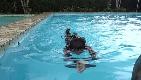 Asiatischer-Junge,-Der-Im-Pool-Schwimmt