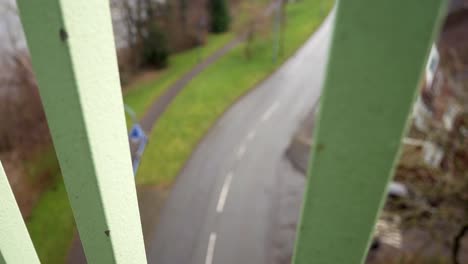Looking-down-between-metal-bridge-footbridge-railings-to-road-below-depression-feeling-slow-left-dolly