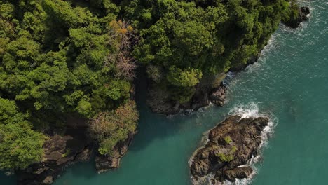 Aerial-ascend-over-tropical-island-and-rain-forest-with-ocean-and-rocky-coastline