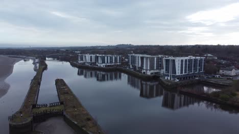 Early-morning-aerial-view-riverside-waterfront-contemporary-apartment-office-buildings-canal-regeneration-real-estate-orbit-left-wide
