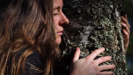 Mujer-Natural-Abrazando-Un-árbol-Con-Los-Ojos-Cerrados-Conectando-Con-La-Naturaleza,-Primer-Plano
