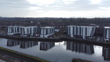 Early-morning-aerial-view-riverside-waterfront-contemporary-apartment-office-buildings-canal-regeneration-real-estate-slow-right-dolly