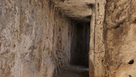 View-down-an-outer-corridor-of-an-ancient-Roman-necropolis-in-Anavargos-Paphos,-Cyprus
