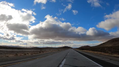 Conduciendo-Por-Una-Carretera-A-Través-Del-Desierto-De-Mojave-En-Un-Hermoso-Día---Punto-De-Vista