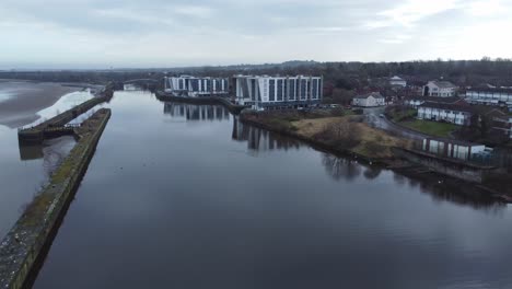 Early-morning-aerial-view-riverside-waterfront-contemporary-apartment-office-buildings-canal-regeneration-real-estate-descending-dolly-right