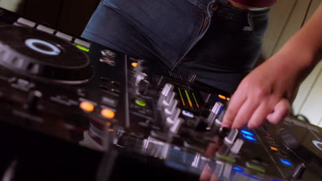 A-mixer-and-turntables-as-a-DJ-turns-the-knobs-and-dances-in-slow-motion