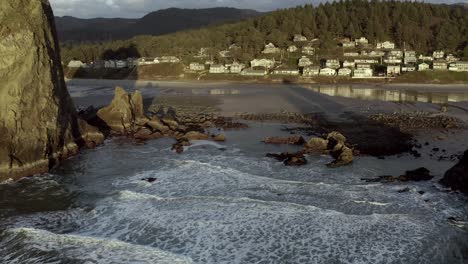 Cannon-Beach,-pullback-aerial-of-Haystack-Rock-at-sunset,-Oregon