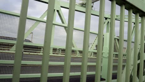 train-passing-Industrial-steel-bridge-strong-girder-beam-support-framework-slow-left-dolly