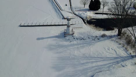 Luftaufnahmen-Von-Drohnen-Eines-Leuchtturms-über-Einem-Zugefrorenen-See-In-Amerika-Im-Winter-In-Chautauqua-County-In-Lakewood,-New-York