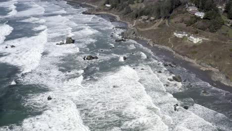Amazing-aerial-forward-view-over-ocean-waves-crashing-on-rocky-coast,-Brookings