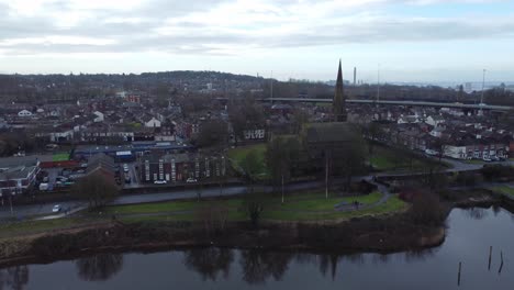 Runcorn-old-town-waterfront-aerial-view-suburban-residential-property-housing-and-church-spire-district-push-in-right