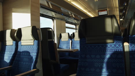 View-of-train-seats-reflecting-the-sun-path-and-shadow-move-projected-through-the-carriage-windows---Medium-close-up-static-shot