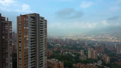 Drone-Rises-to-Reveal-Medellin,-Colombia-Skyscrapers-on-Beautiful-Day