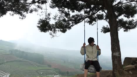 a-portrait-of-a-man-swinging-on-a-hilltop