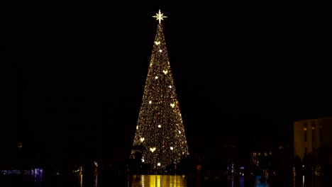Weihnachtsbaum-Mit-Bunten-Lichtern-Im-Stadtzentrum-Und-Menschen,-Die-Die-Festliche-Atmosphäre-Des-Neuen-Jahres-Genießen