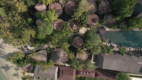 Aerial-view-of-a-hotel-rooftop-from-a-drone-with-beach-and-palm-trees