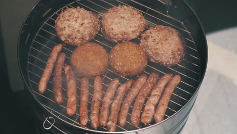 Top-down-view-of-grilled-burgers-and-sausages-outdoors