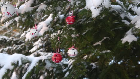 Panning-shot-of-spruce-tree-covered-in-snow-to-reveal-Christmas-decoration