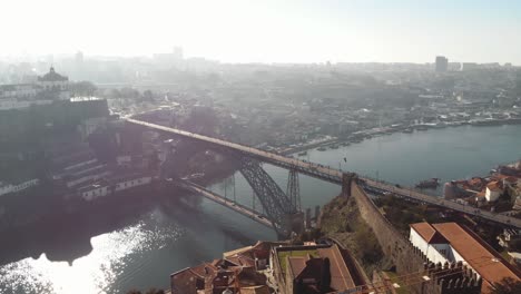 4k-Luftaufnahmen-Von-Drohnen-Der-Stahlbrücke,-Die-Sich-über-Den-Flusskanal-Der-Küstenstadt-Porto-Im-Nordwesten-Portugals-Erstreckt