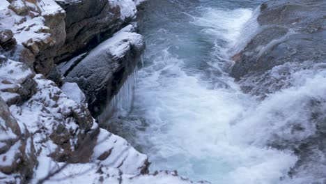Syterbacken-frozen-icy-brook-cascading-down-in-Hemavan,-Sweden---High-angle-close-up