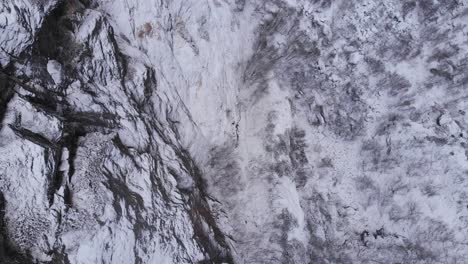 Bird's-eye-view-of-Scandes-mountain-range-harsh-frozen-stone-walls---Aerial-shot
