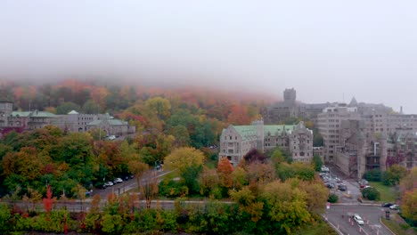 Drone-pulling-away-from-baronial-old-building-located-on-the-Mount-Royal-mountain-on-a-colourful-fall-misty-morning