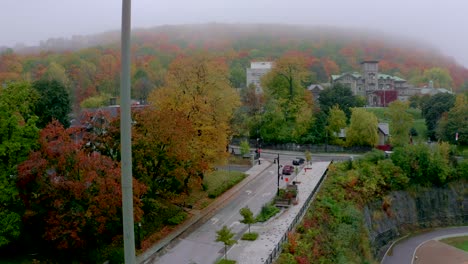 Drone-moving-up-on-a-light-spot-revealing-the-beautiful-and-colourful-Mount-Royal-in-Montreal-on-a-foggy-fall-morning