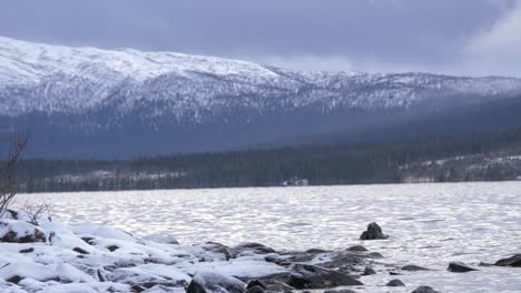 Nordic-lake-and-frozen-landscape-in-Hemavan-Tarnaby,-in-Sweden---Low-angle-wide-shot
