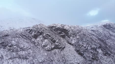 Long-Rocky-snowed-ridge-in-the-Scandinavian-Mountain-range---Fast-aerial-wide-shot