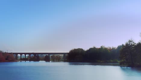 A-time-lapse-shot-with-a-camera-pan-over-the-lake-and-a-railway-bridge